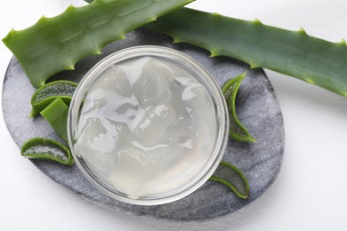 Photo of Aloe vera gel and slices of plant on white background, top view