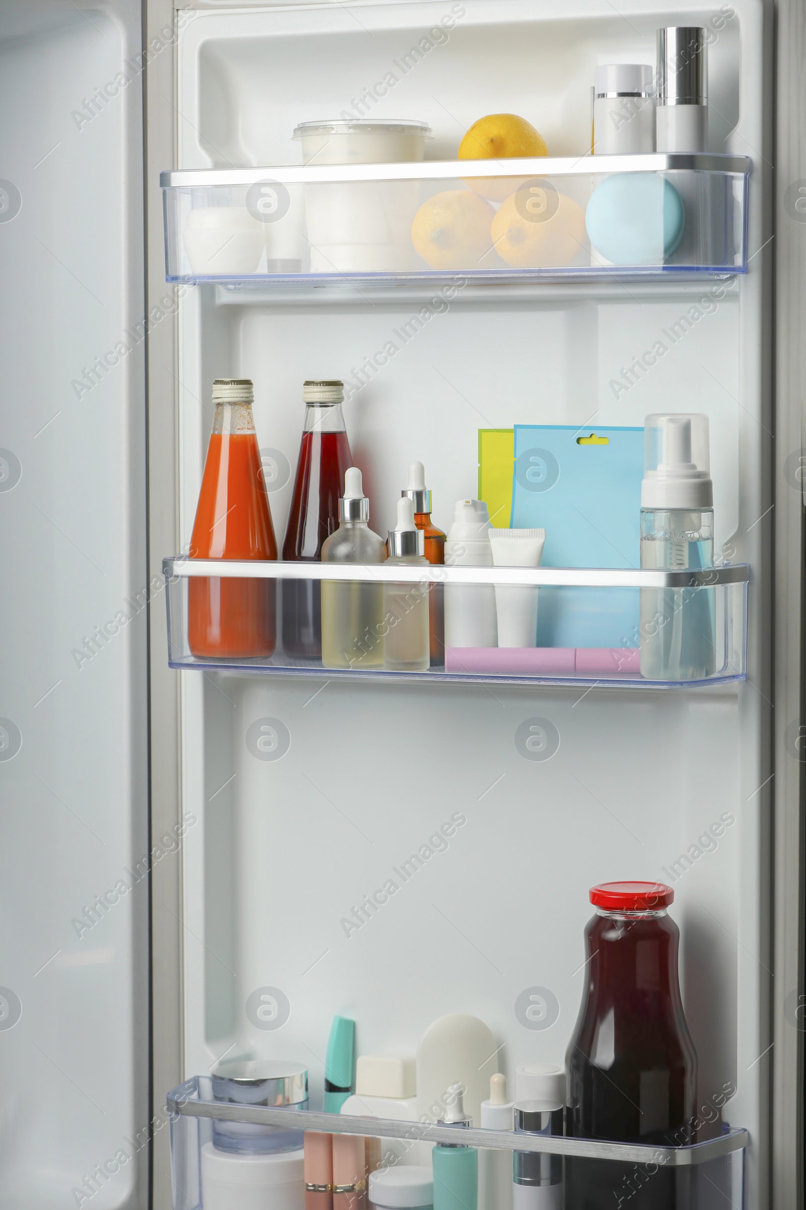 Photo of Different cosmetic products on shelves in refrigerator