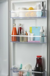 Different cosmetic products on shelves in refrigerator