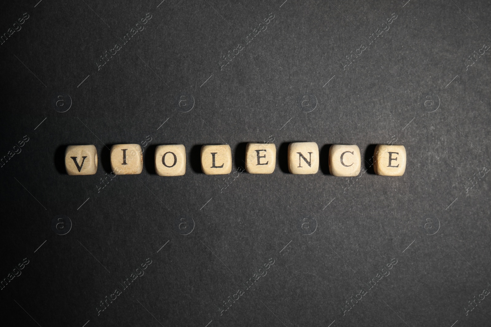 Photo of Word VIOLENCE made of wooden cubes on black background, flat lay