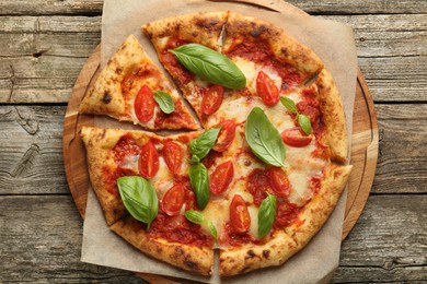 Photo of Delicious Margherita pizza on wooden table, top view