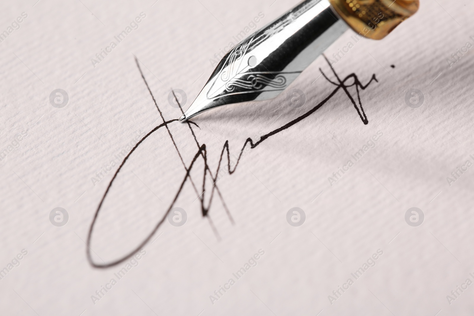 Photo of Signing on sheet of paper with fountain pen, closeup