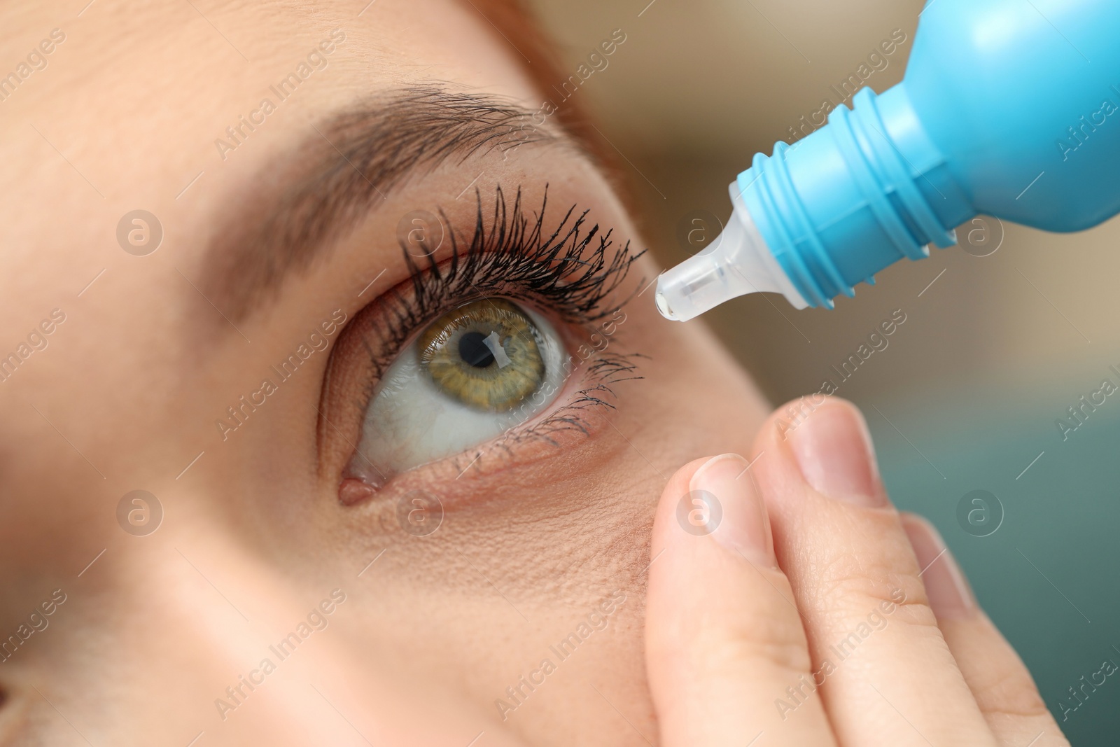 Photo of Woman applying medical eye drops, macro view