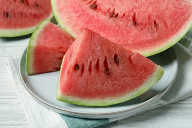 Photo of Slices of tasty ripe watermelon on white wooden table, closeup