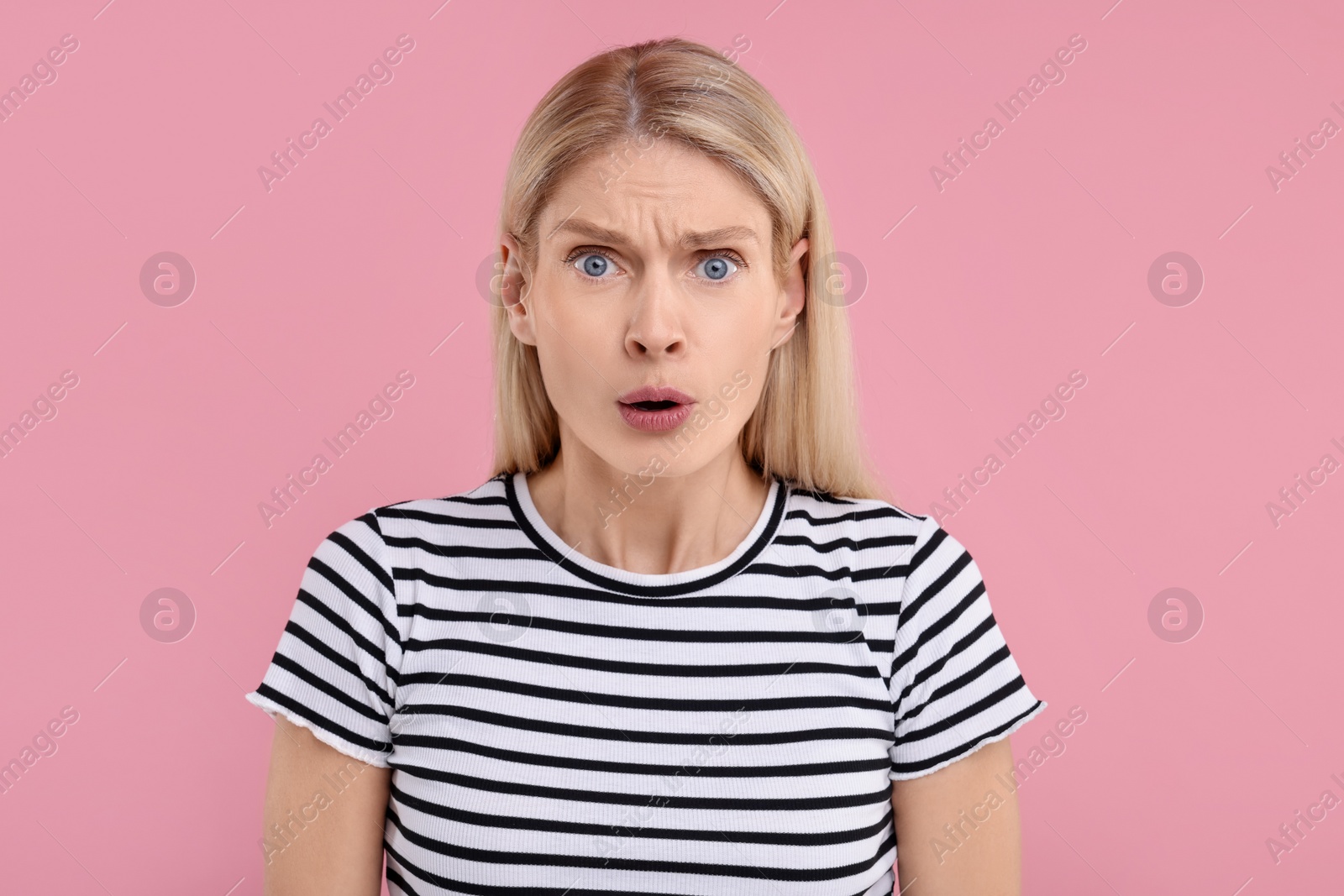 Photo of Portrait of surprised woman on pink background