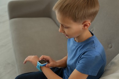 Boy with stylish smart watch on sofa