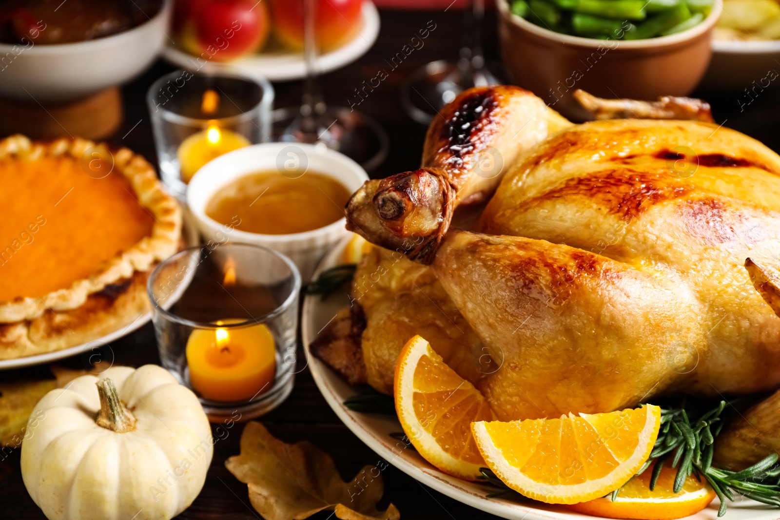 Photo of Traditional Thanksgiving day feast with delicious cooked turkey and other seasonal dishes served on table, closeup
