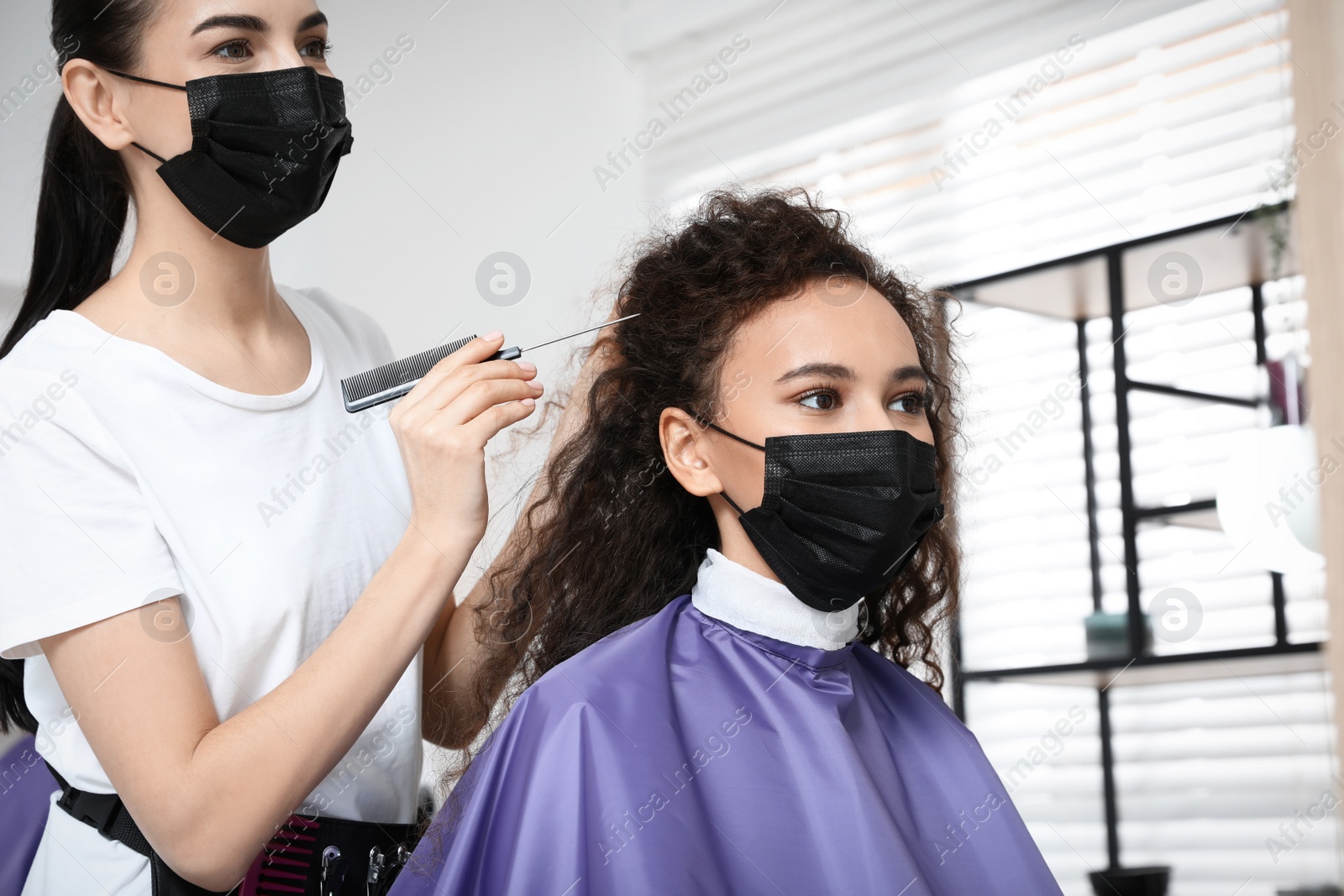 Photo of Professional stylist working with client in salon. Hairdressing services during Coronavirus quarantine