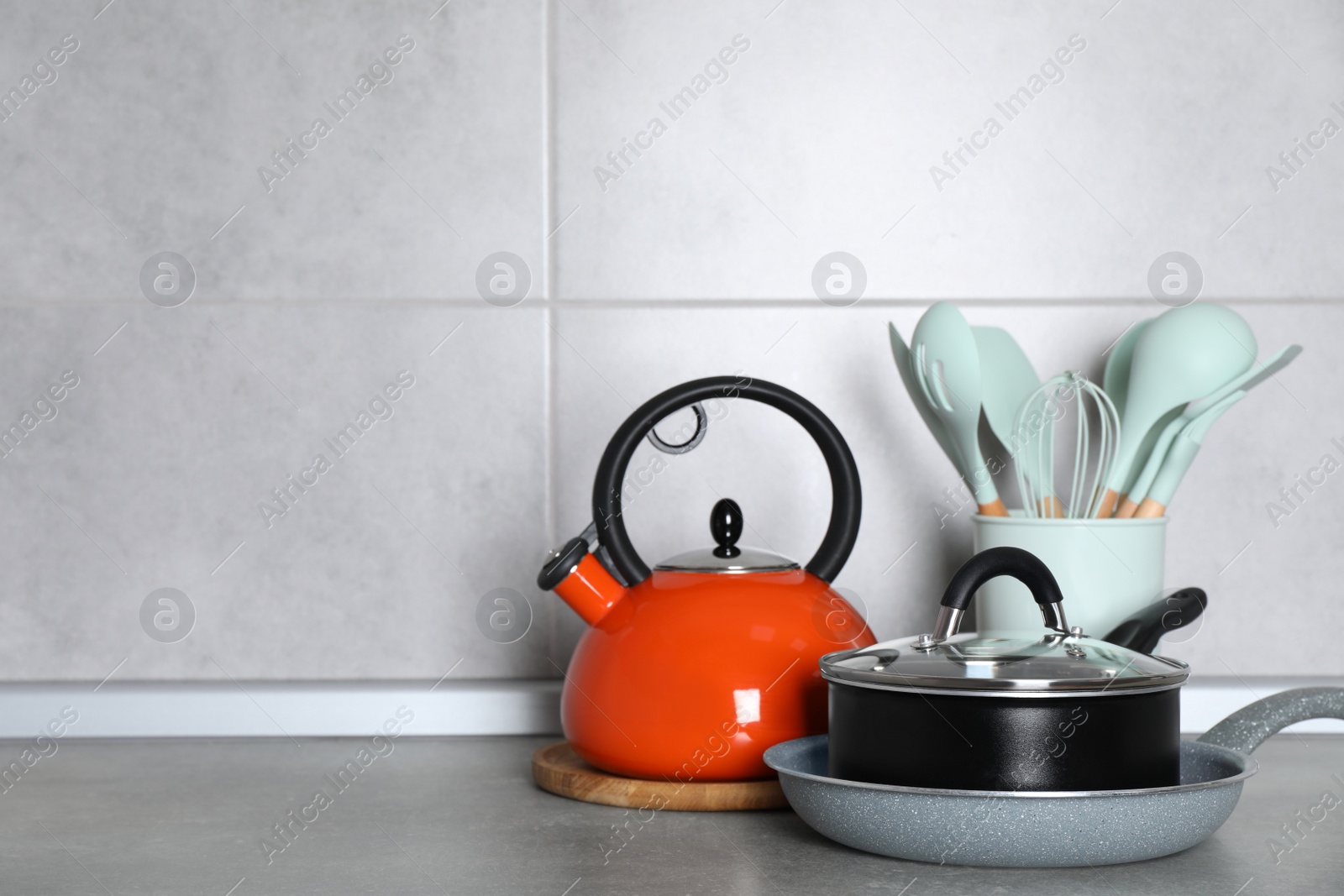 Photo of Cooking utensils and other kitchenware on grey countertop. Space for text