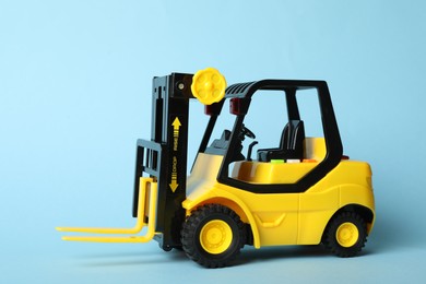 Toy forklift on blue background. Logistics and wholesale concept