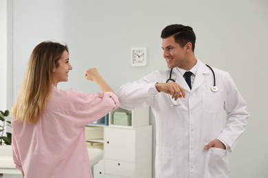 Photo of Doctor and patient doing elbow bump instead of handshake in clinic. New greeting during COVID-19 pandemic