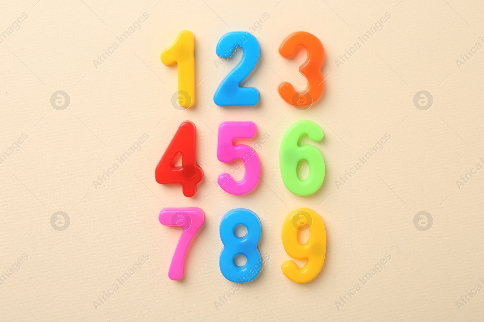 Photo of Colorful numbers on beige background, flat lay