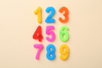 Photo of Colorful numbers on beige background, flat lay