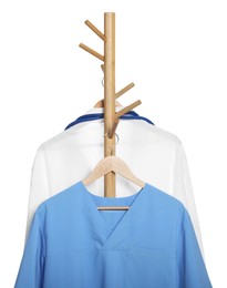 Photo of Light blue medical uniform and doctor's gown on rack against white background