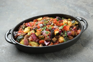 Photo of Dish with tasty ratatouille on grey textured table