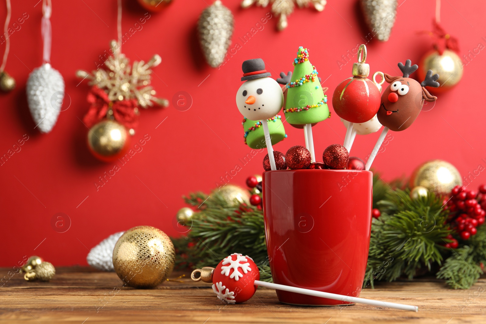 Photo of Delicious Christmas themed cake pops and festive decor on wooden table