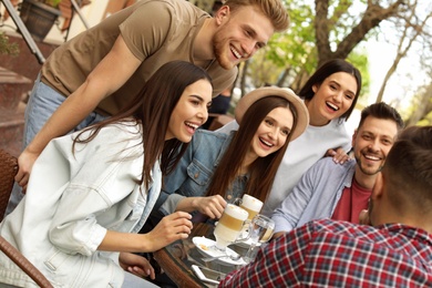 Photo of Happy people spending time together at outdoor cafe