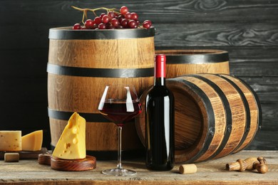 Photo of Winemaking. Composition with tasty wine and barrels on wooden table