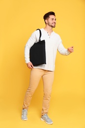 Photo of Full length portrait of young man with eco bag on yellow background