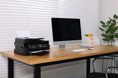 Photo of Stylish room interior with desk, modern printer and computer