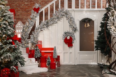 Photo of Christmas tree, gift boxes and festive decor indoors. Interior design