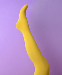 Photo of Leg mannequin in yellow tights on violet background