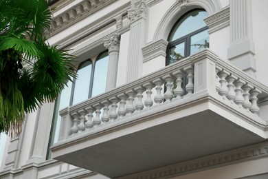 Photo of Exterior of beautiful building with balcony and palm tree outdoors