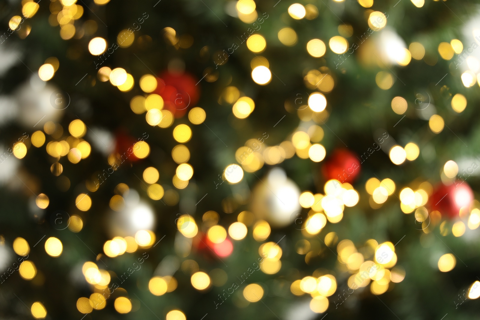 Photo of Blurred view of Christmas tree with bright fairy lights and ornaments, closeup. Bokeh effect