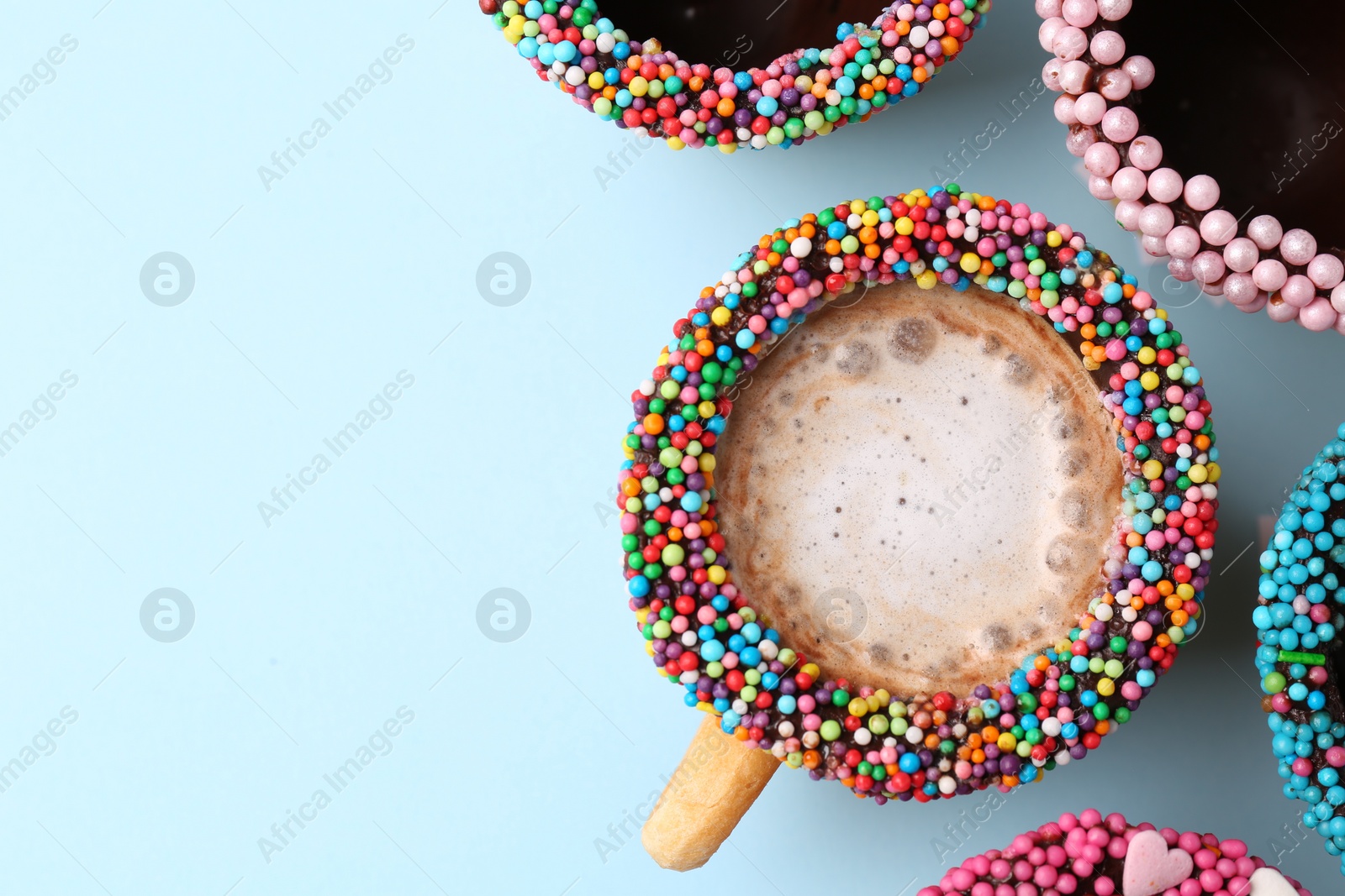 Photo of Many delicious edible biscuit cups on light blue background, flat lay. Space for text