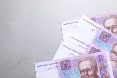 Photo of Ukrainian money on grey background, flat lay. Space for text