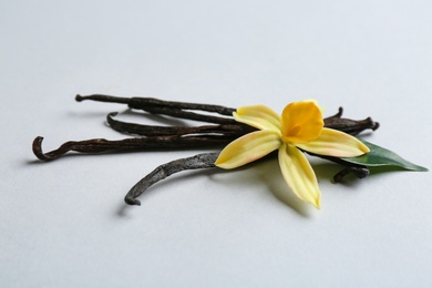Photo of Vanilla sticks and flower on light background
