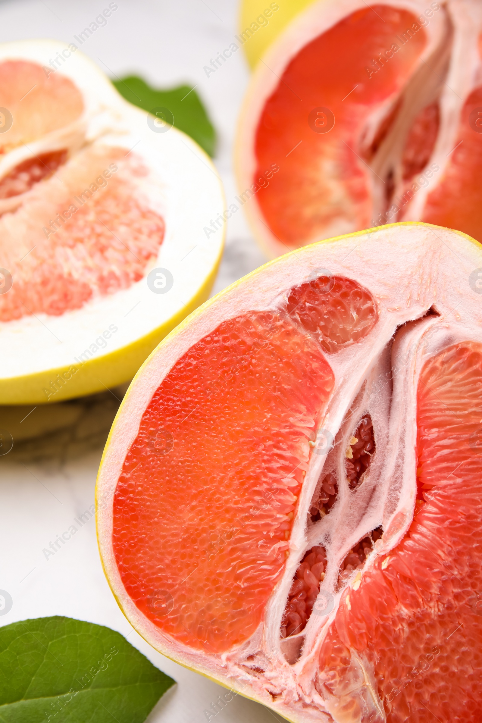 Photo of Different tasty pomelo fruits on white marble table, closeup