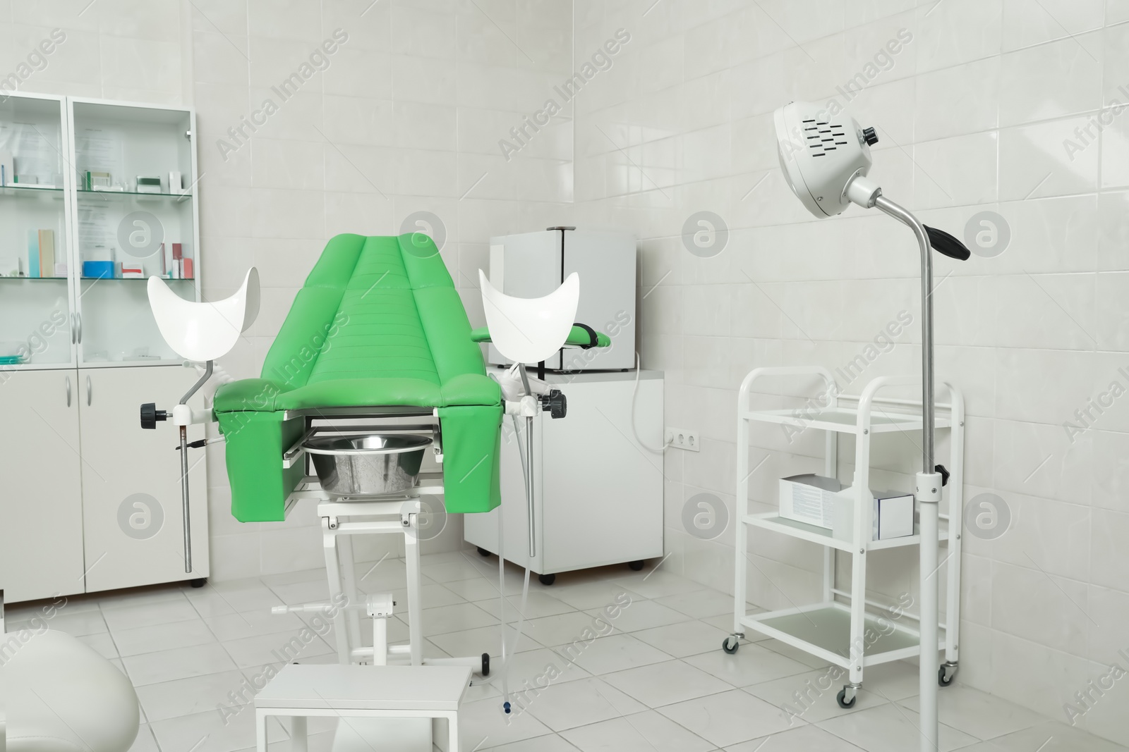 Photo of Modern gynecological office interior with examination chair and medical equipment