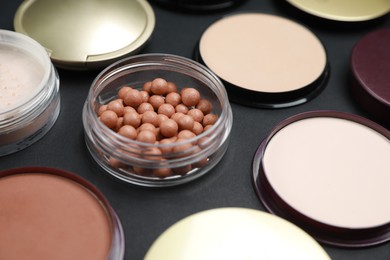 Photo of Different face powders on black table, closeup