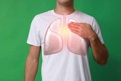 Man holding hand near chest with illustration of lungs on green background, closeup