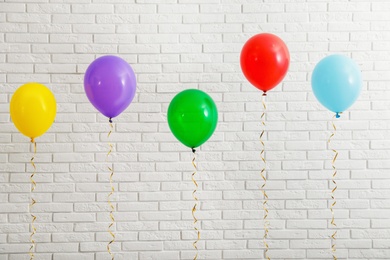 Bright balloons near brick wall. Celebration time