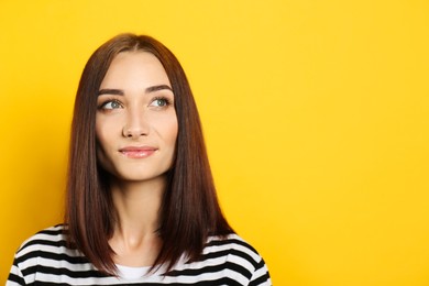 Photo of Portrait of pretty young woman with gorgeous chestnut hair on yellow background, space for text