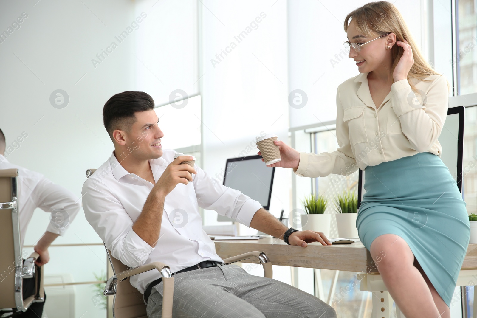 Photo of Colleagues flirting with each other during coffee break in office