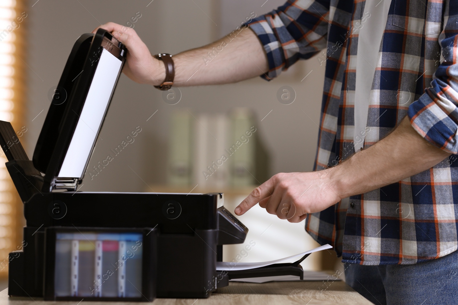 Photo of Man using modern multifunction printer in office, closeup