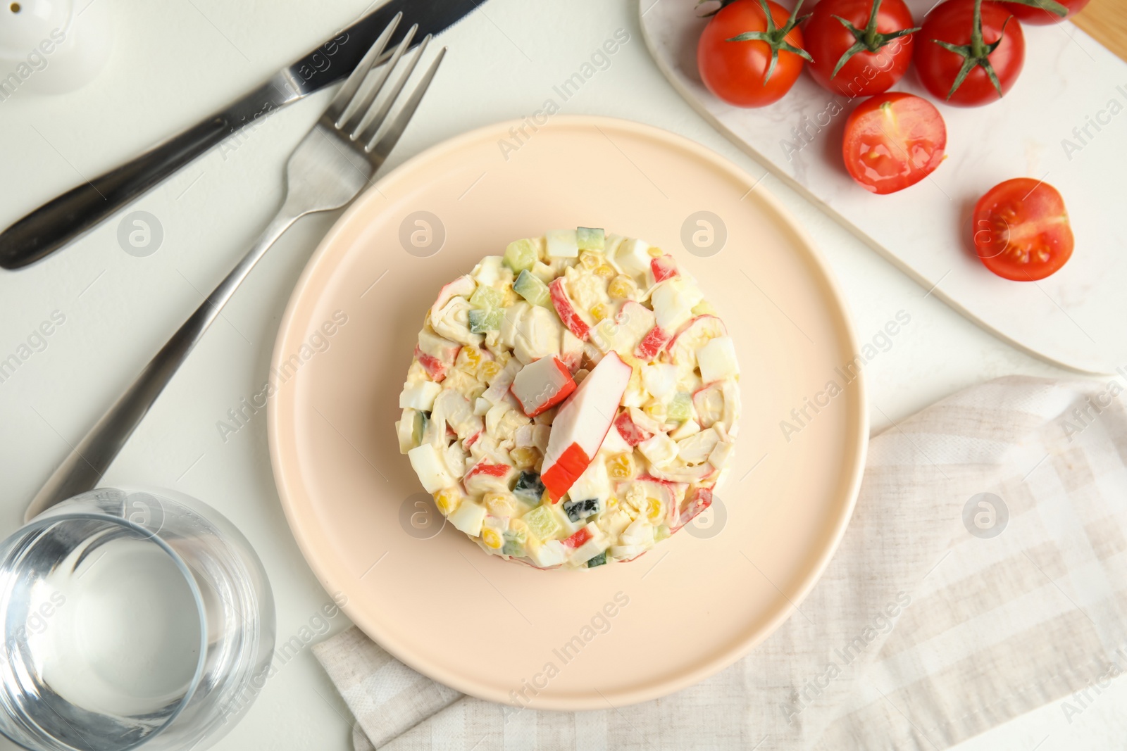 Photo of Delicious salad with crab sticks served on white table, flat lay