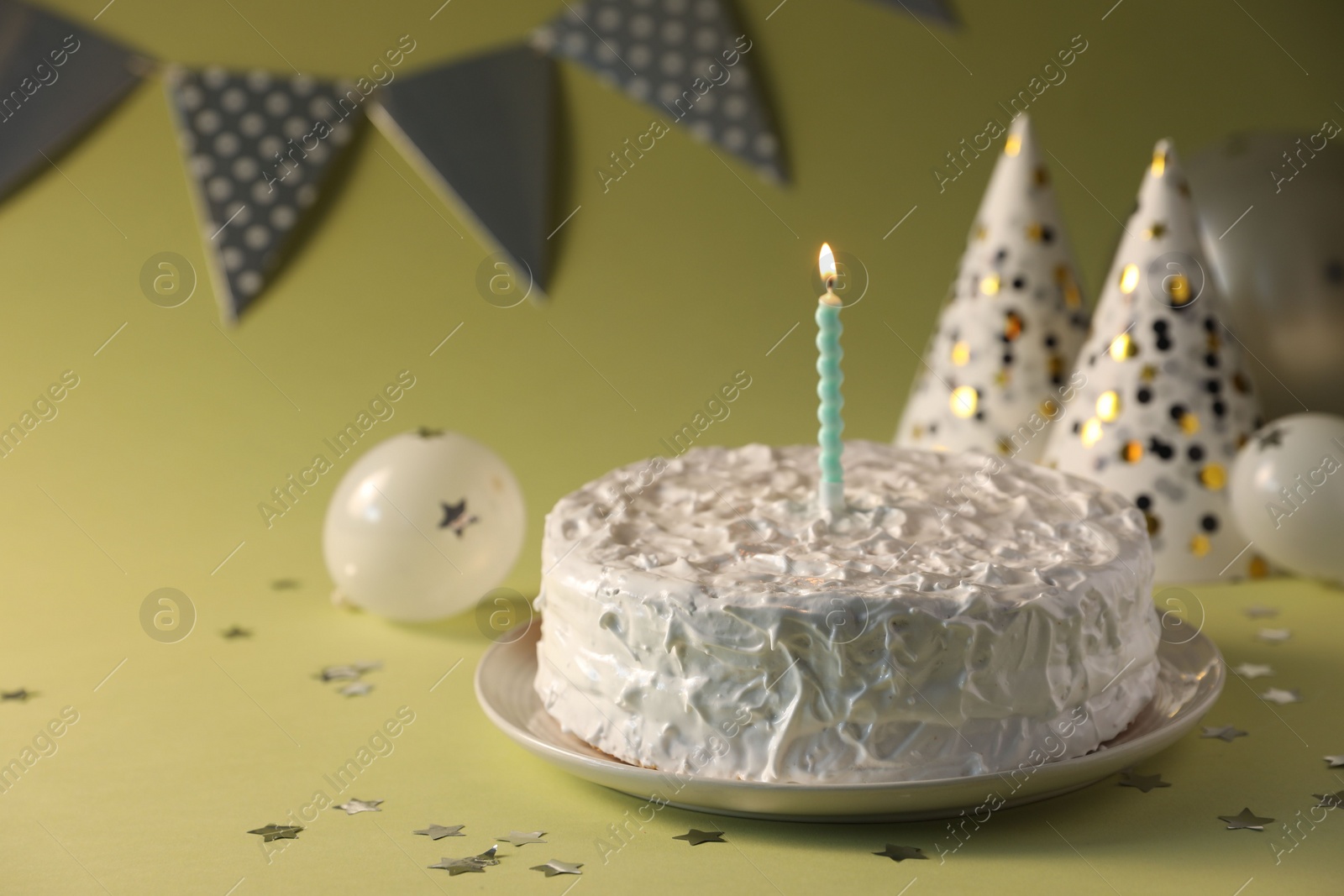 Photo of Tasty cake with burning candle on green background, closeup. Space for text