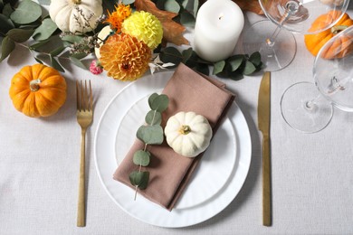 Beautiful autumn table setting. Plates, cutlery, glasses and floral decor, flat lay