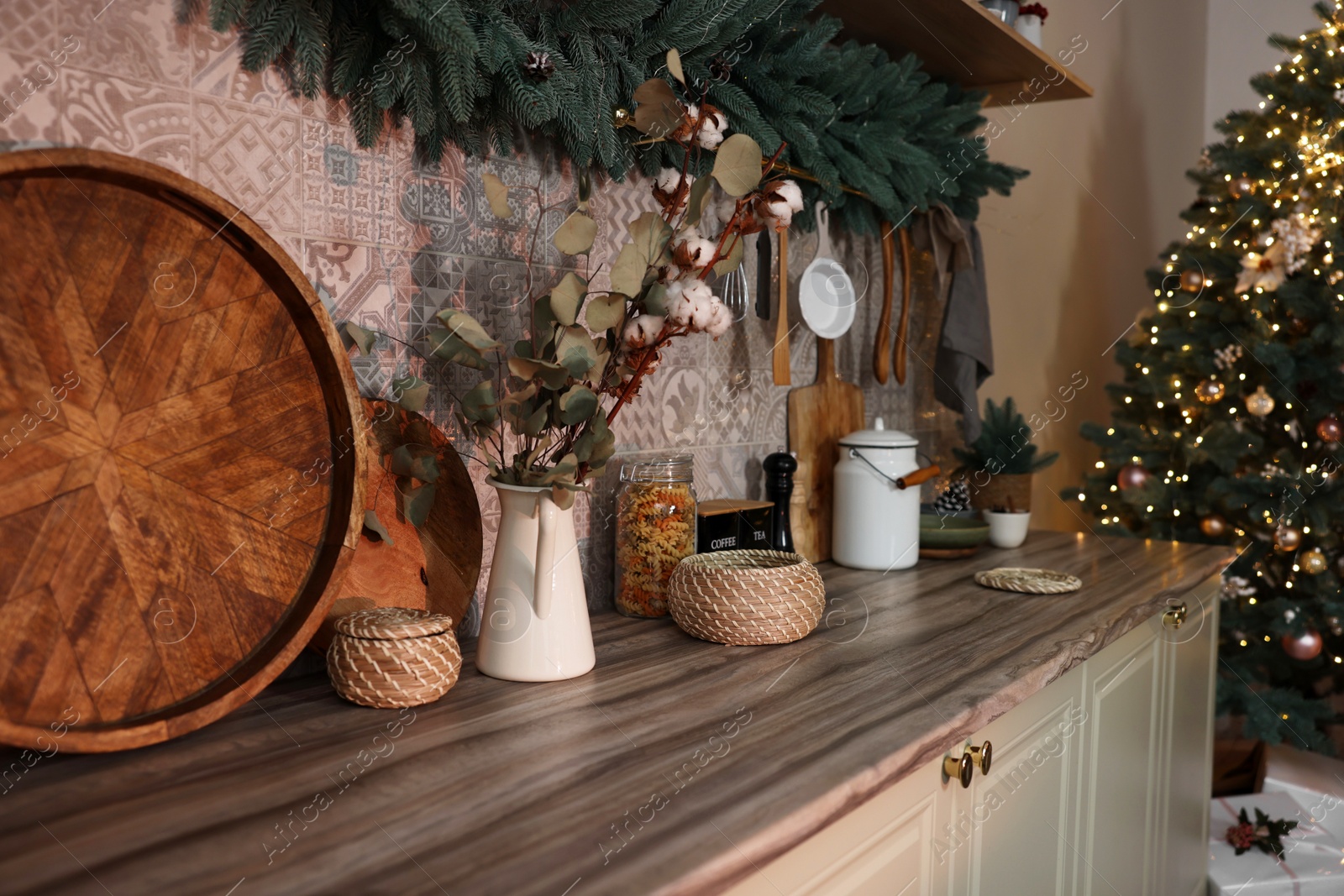 Photo of Stylish kitchen with festive decor and Christmas garland. Interior design