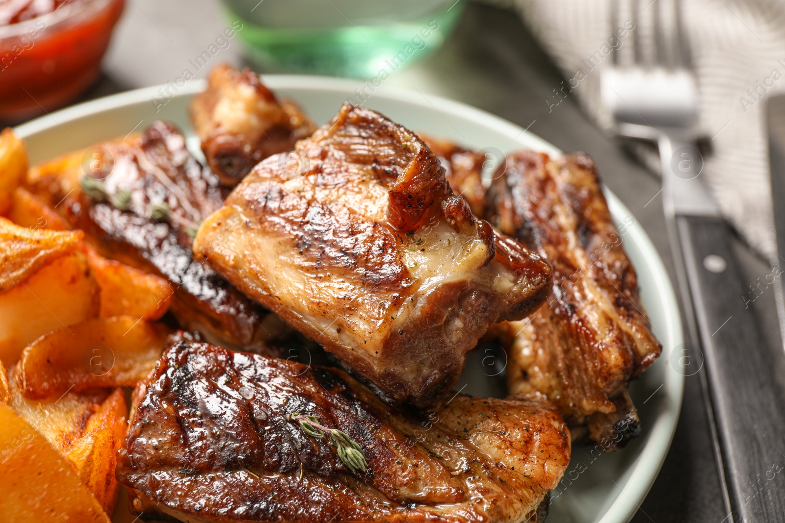 Photo of Delicious grilled ribs served on table, closeup