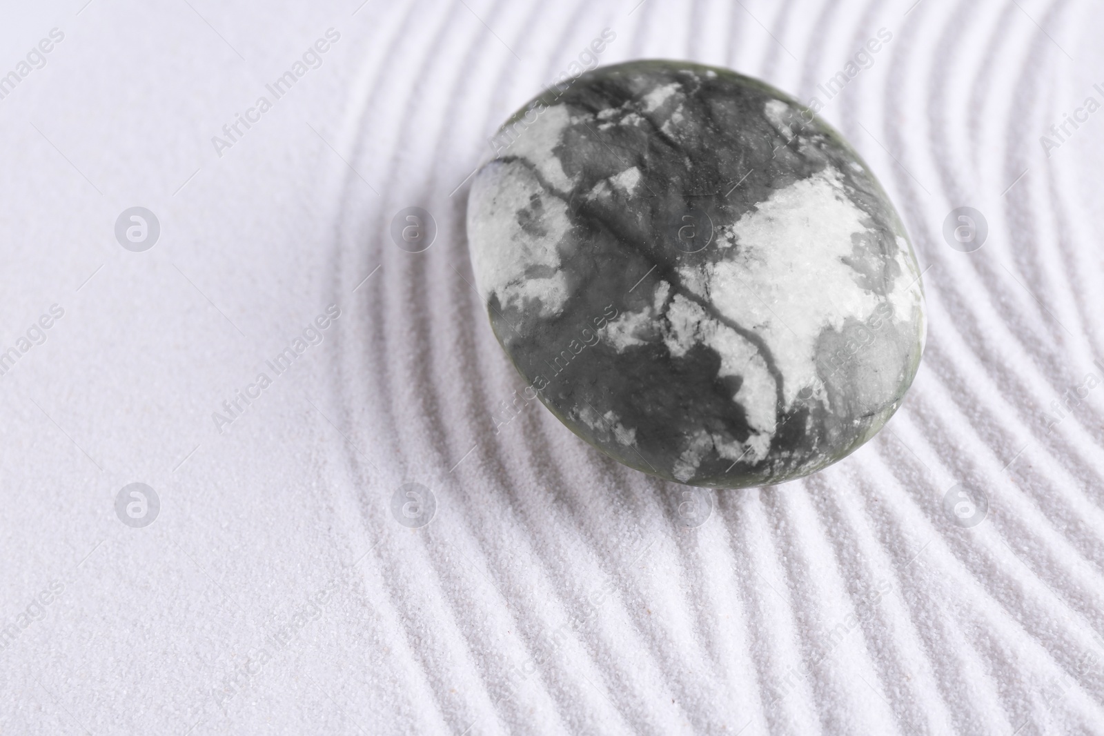 Photo of Zen concept. Stone and pattern on white sand, closeup. Space for text