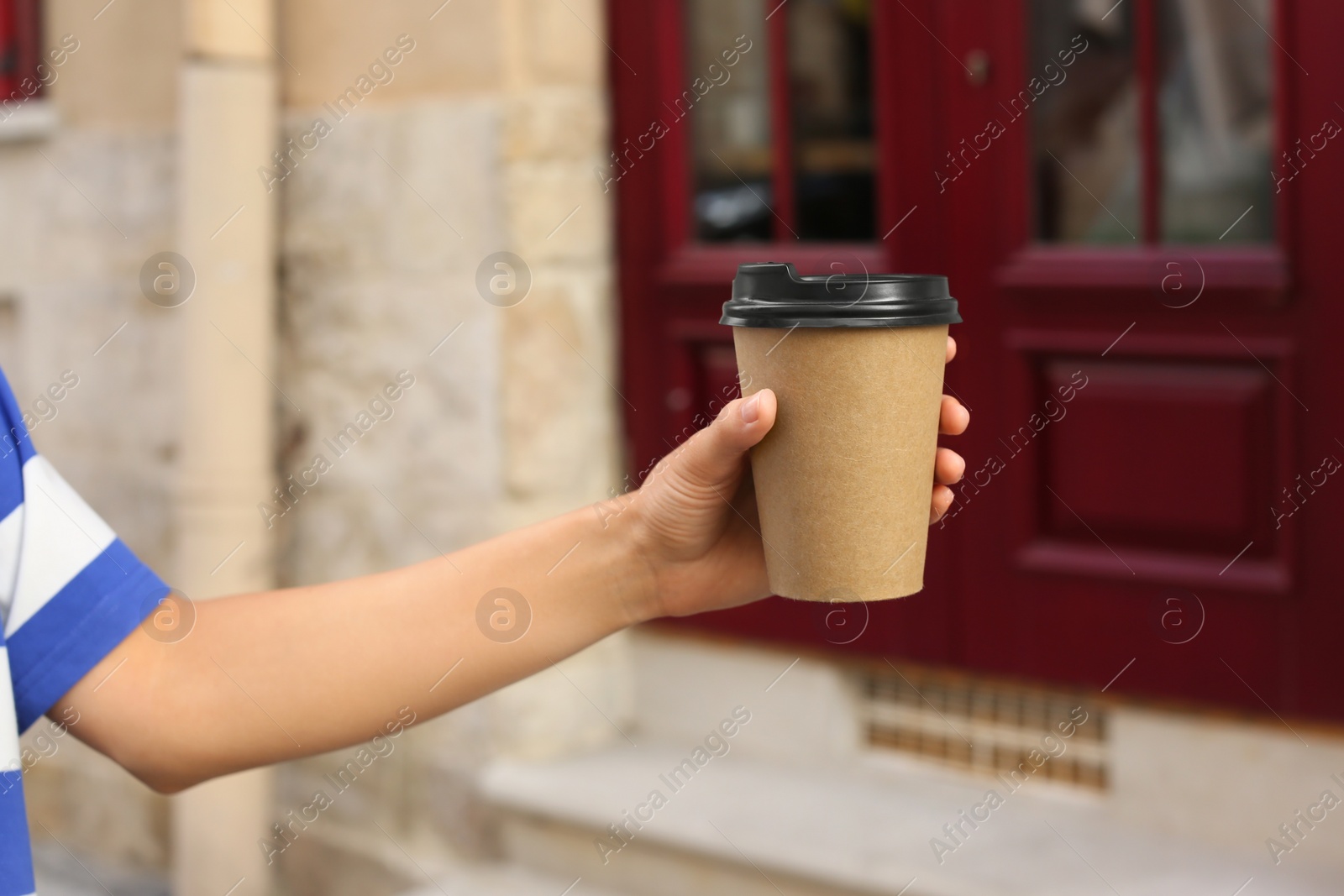 Photo of Coffee to go. Woman with paper cup of drink outdoors, closeup