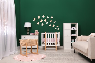 Beautiful baby room interior with stylish furniture and wicker cradle