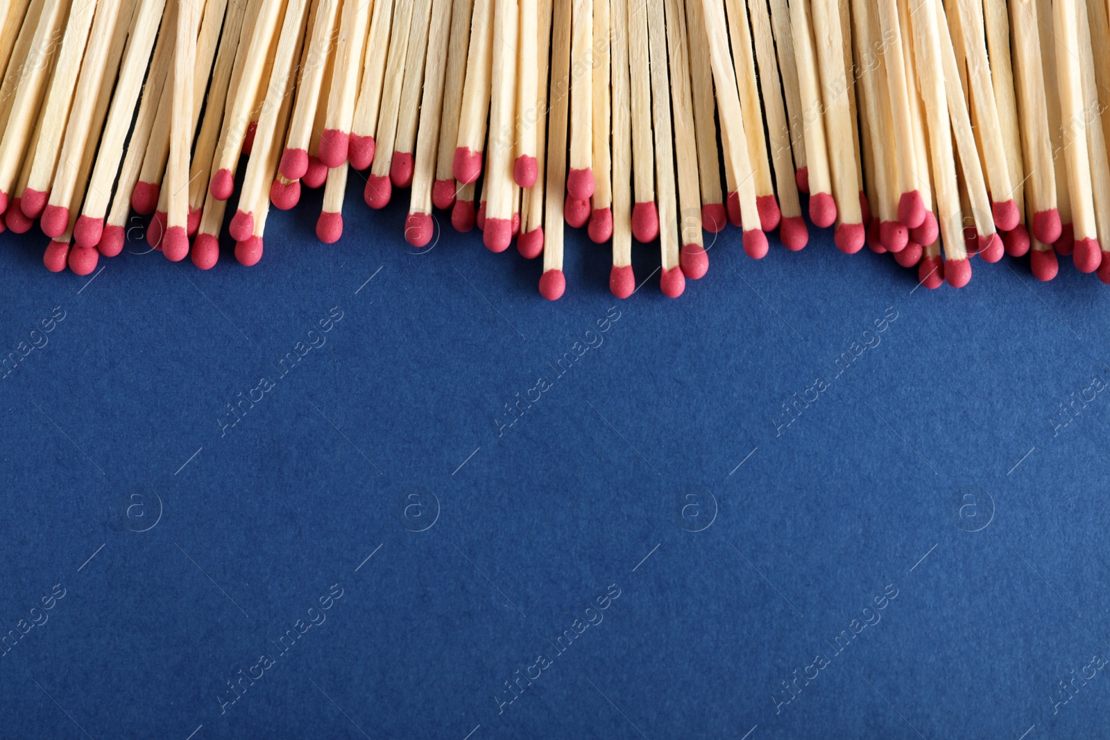Photo of Many matches on color background, top view with space for text