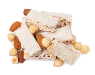 Photo of Many pieces of delicious nougat and nuts on white background, top view