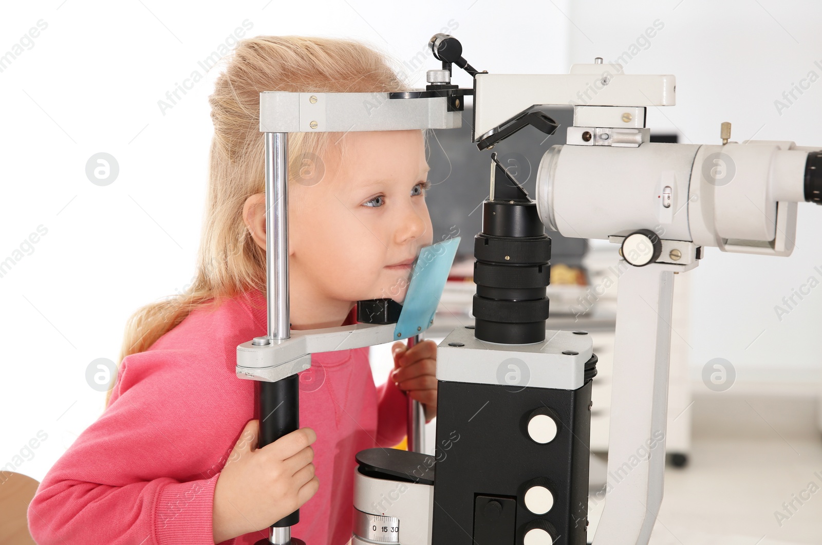 Photo of Cute little girl visiting children's doctor. Eye examination